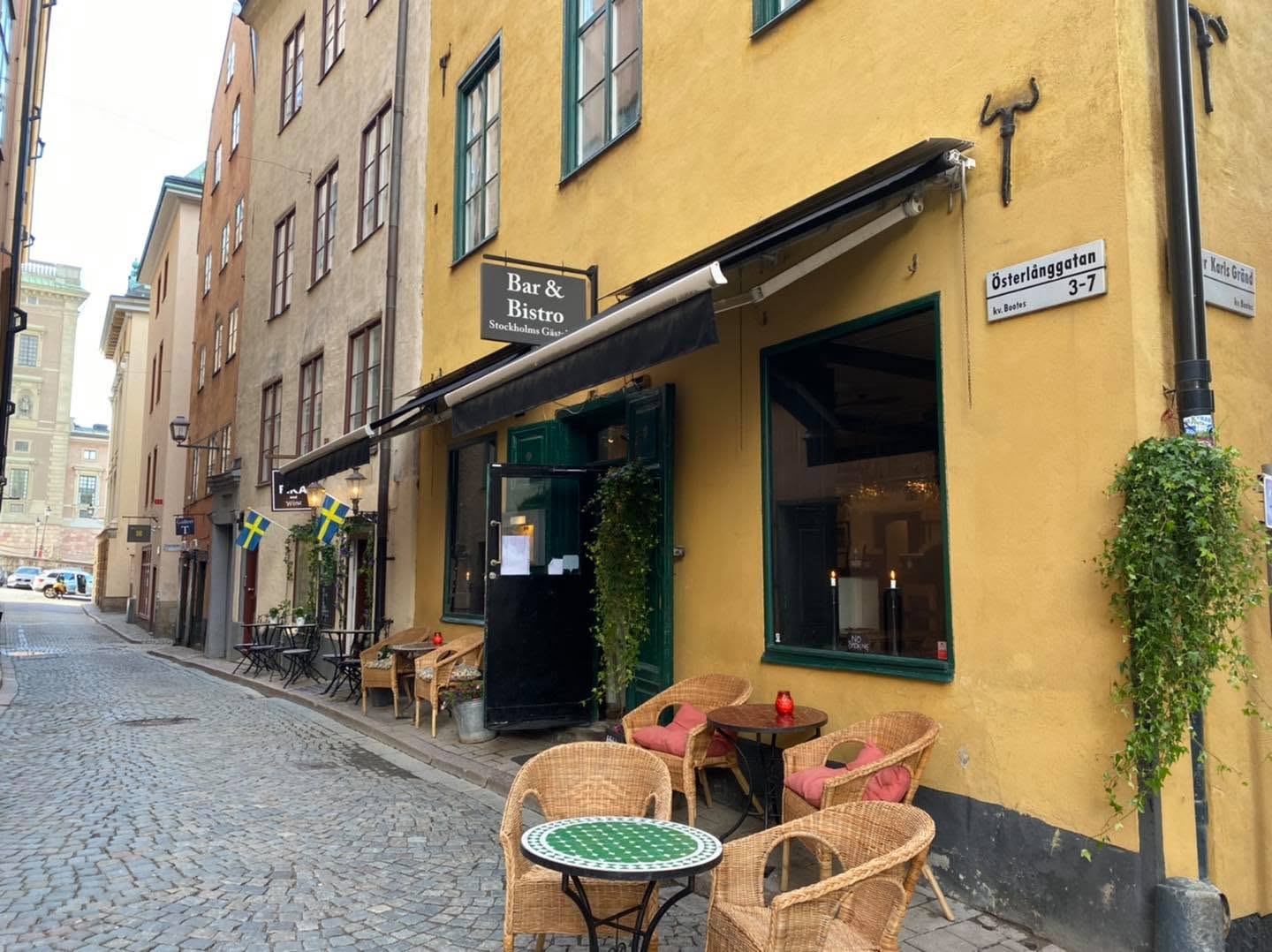 Stockholms Gästabuds fasad på Österlånggatan med uteservering en solig dag